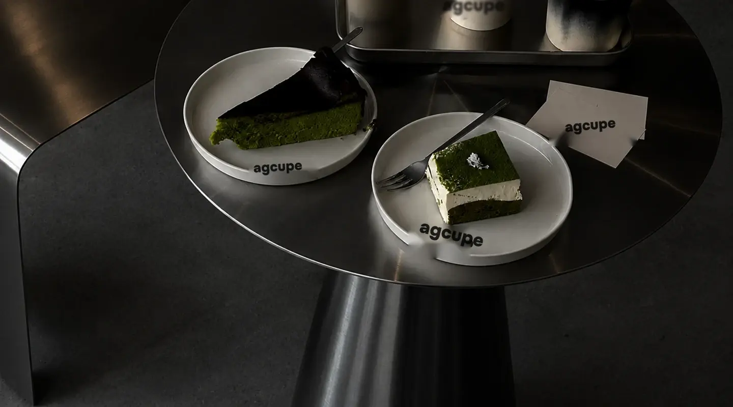Two matcha cakes on agcupe plates on a steel side table